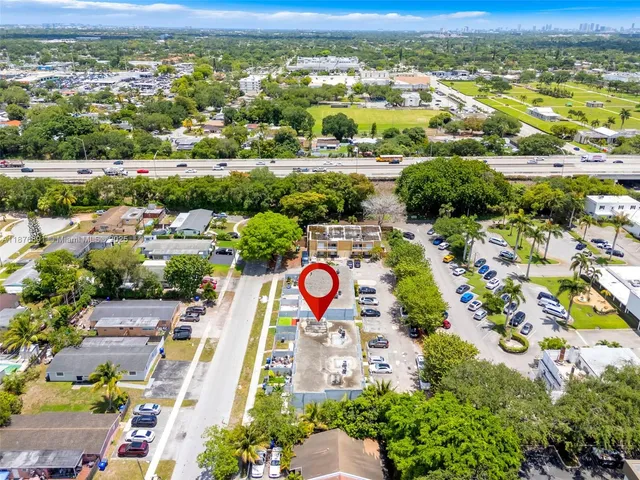 an aerial view of residential houses with outdoor space and parking