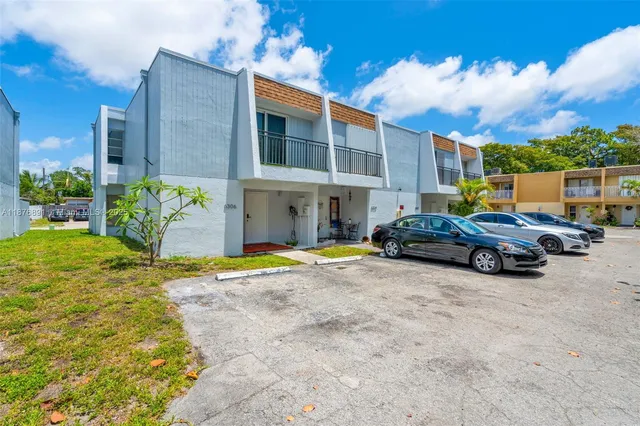 a view of a house with cars parked