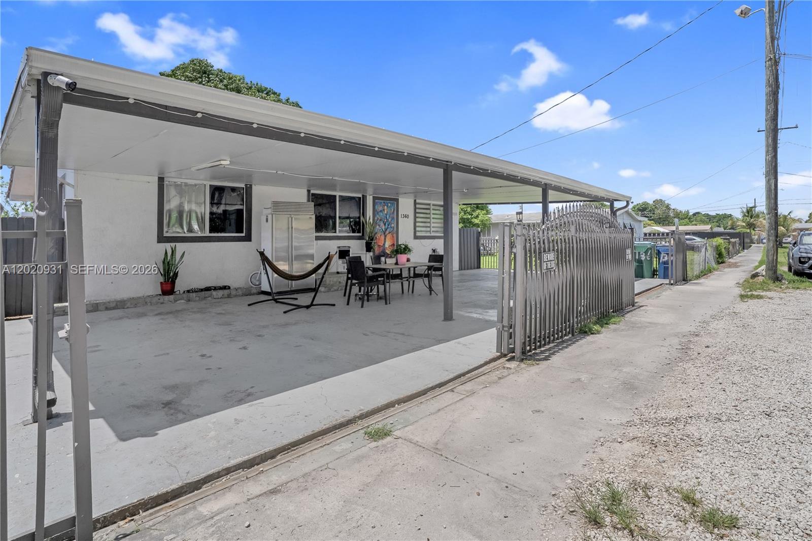 1360 Northwest 77th Street Miami, FL 33147 - Photo 3 of 41 a view of a patio with table and chairs with wooden floor and fence