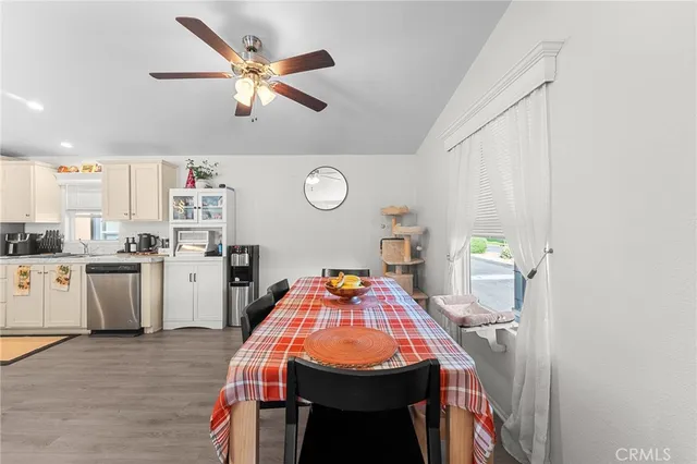 a dining room with kitchen island stainless steel appliances furniture cabinets and a window