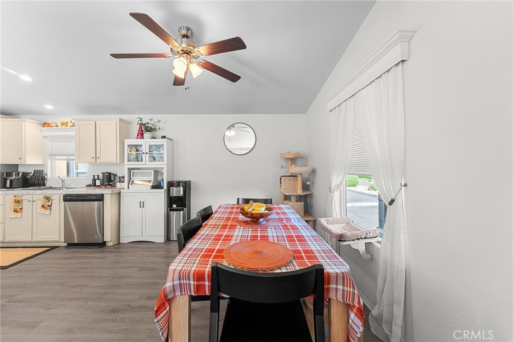 4901 Green River Road, Unit 96 Corona, CA 92878 - Photo 14 of 35 a dining room with kitchen island stainless steel appliances furniture cabinets and a window