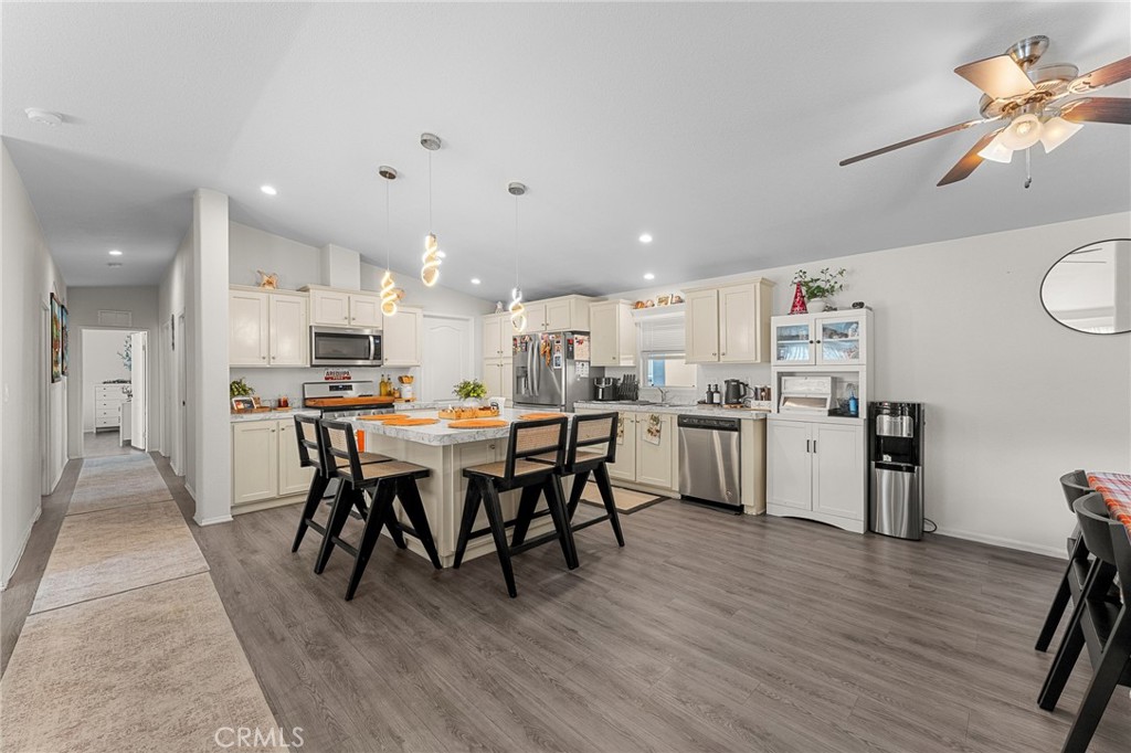 4901 Green River Road, Unit 96 Corona, CA 92878 - Photo 5 of 35 a kitchen with a dining table chairs cabinets wooden floor and appliances