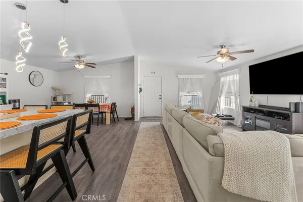 a living room with furniture a flat screen tv and kitchen view