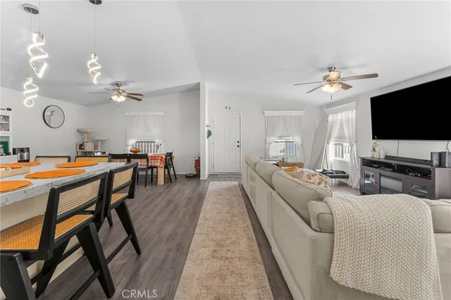a living room with furniture a flat screen tv and kitchen view