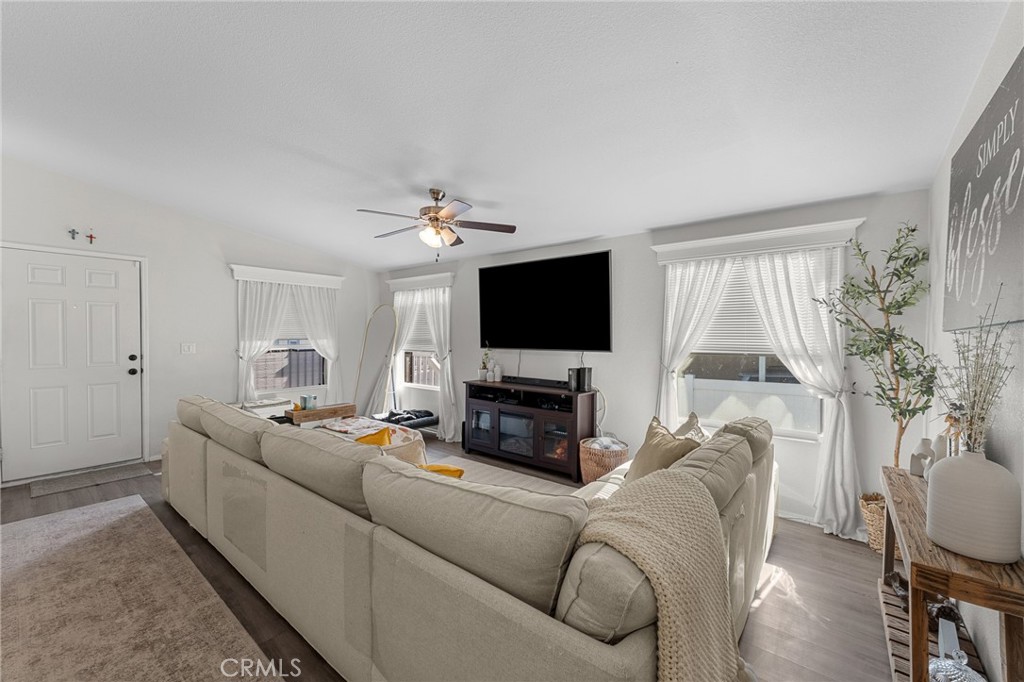 4901 Green River Road, Unit 96 Corona, CA 92878 - Photo 9 of 35 a living room with furniture a flat screen tv and a fireplace