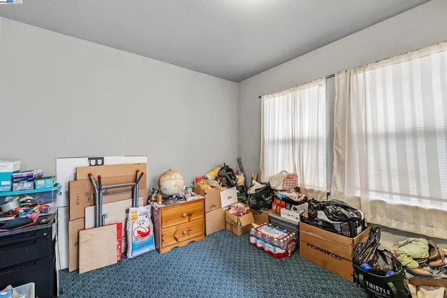 a bedroom with furniture toys and a large window
