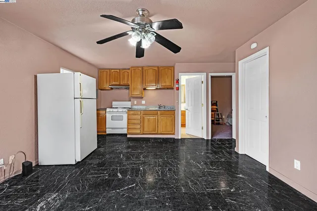 a view of a kitchen with a sink and refrigerator