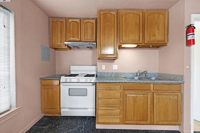 a kitchen with granite countertop cabinets stainless steel appliances and a counter space