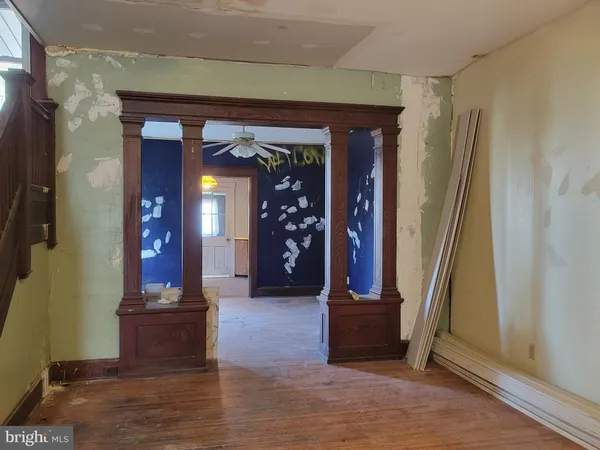 a view of a hallway with wooden floor and a living room