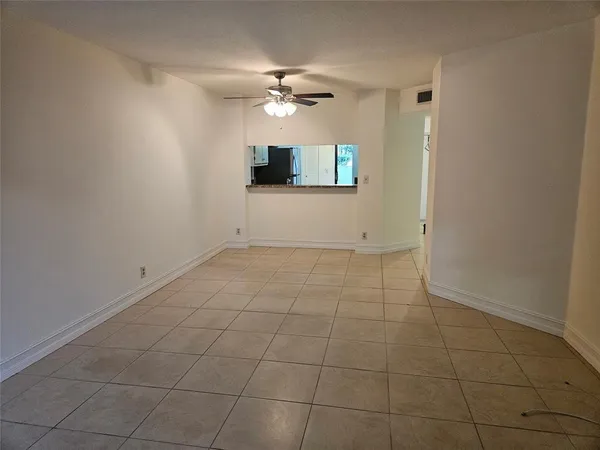 a view of an empty room with a ceiling fan and carpet