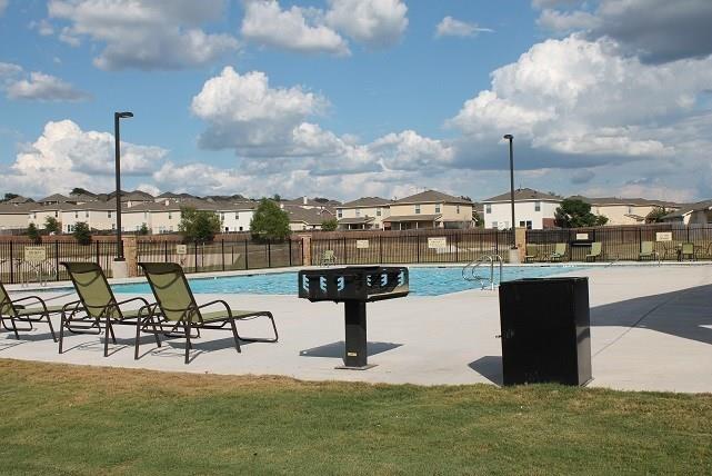 5716 Southerner Way Austin, TX 78747 - Photo 29 of 33 An inviting community pool awaits, framed by comfortable loungers and a well-maintained lawn.