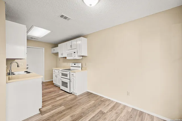 a kitchen with stainless steel appliances a stove top oven a sink and a refrigerator