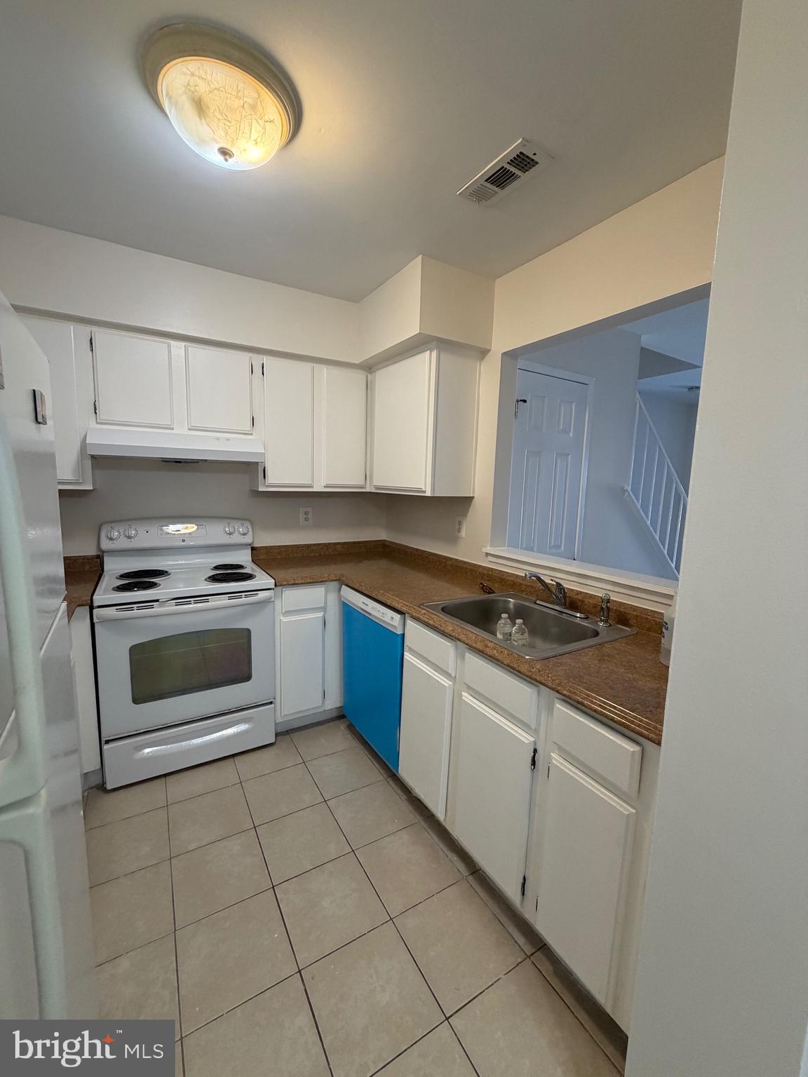 4118 Peppertree Lane, Unit 4118 Silver Spring, MD 20906 - Photo 5 of 30 a kitchen with granite countertop a stove sink and cabinets