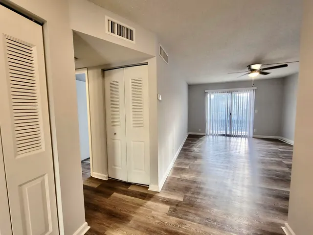 a view of a hallway with wooden floor and staircase