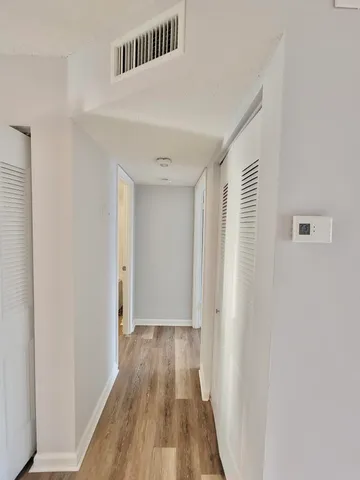 a view of a hallway with wooden floor