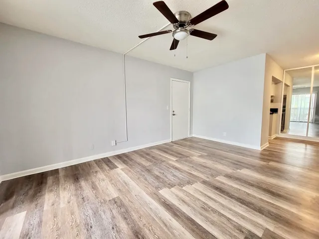 a view of empty room with wooden floor