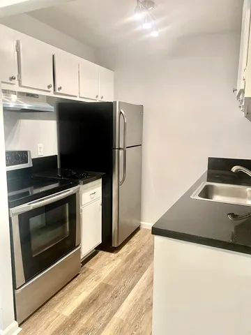 a kitchen with granite countertop a stove and a microwave