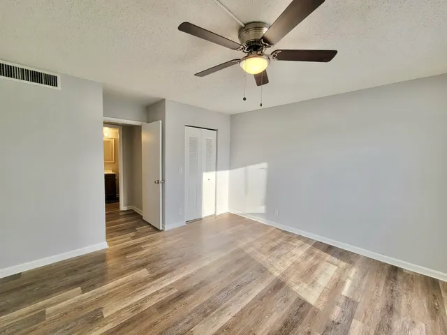 a view of an empty room with wooden floor