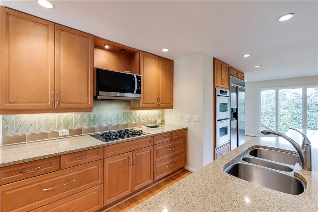 1416 Vernon Ridge Close Atlanta, GA 30338 - Photo 16 of 59 a kitchen with stainless steel appliances granite countertop a sink a stove and a microwave oven with cabinets