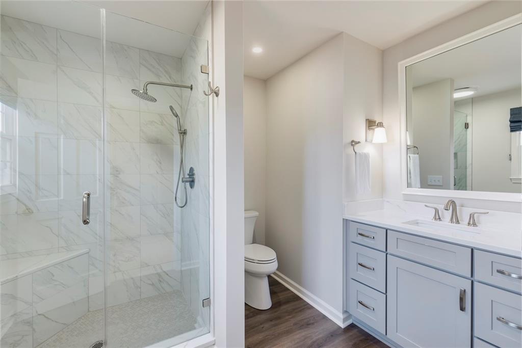 1416 Vernon Ridge Close Atlanta, GA 30338 - Photo 41 of 59 a bathroom with a granite countertop sink a toilet and shower