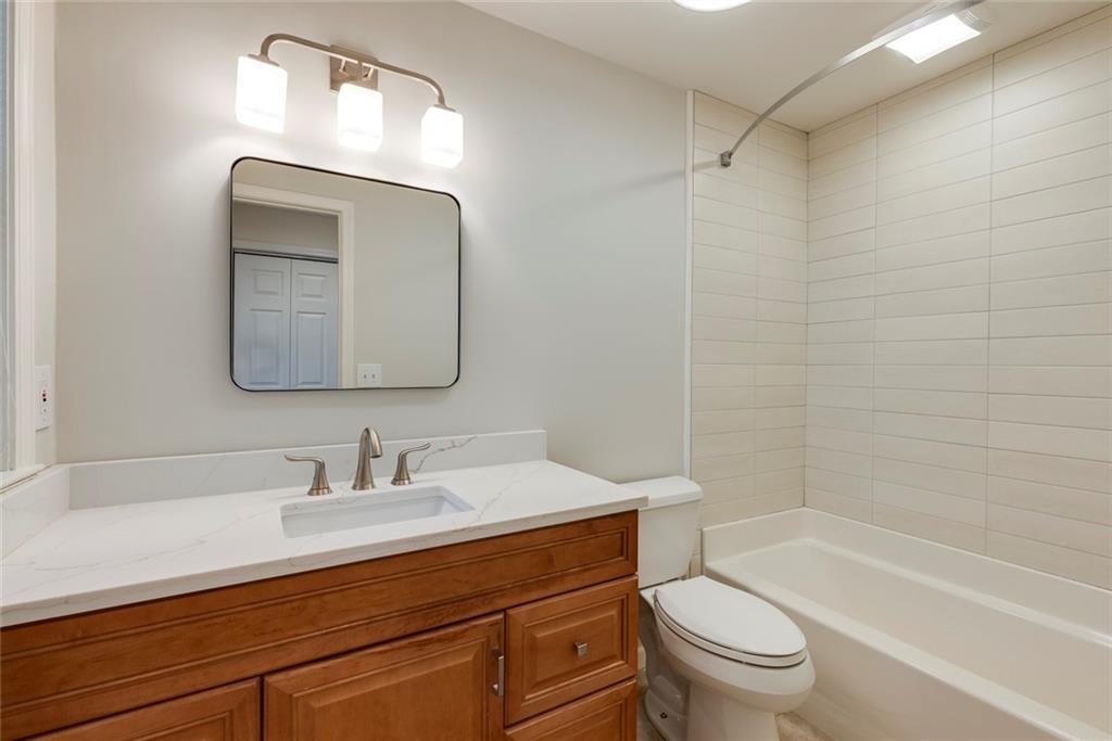 1416 Vernon Ridge Close Atlanta, GA 30338 - Photo 46 of 59 a bathroom with a toilet a sink a mirror a bathtub and vanity