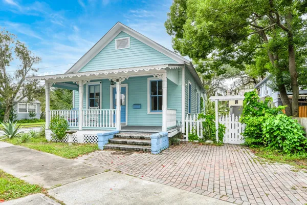 a view of a house with wooden deck and furniture