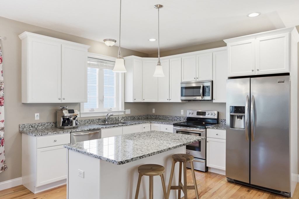 2 Dino Way, Unit 52 Milford, MA 01757 - Photo 12 of 41 a kitchen with stainless steel appliances granite countertop a stove a sink a refrigerator a center island and cabinets