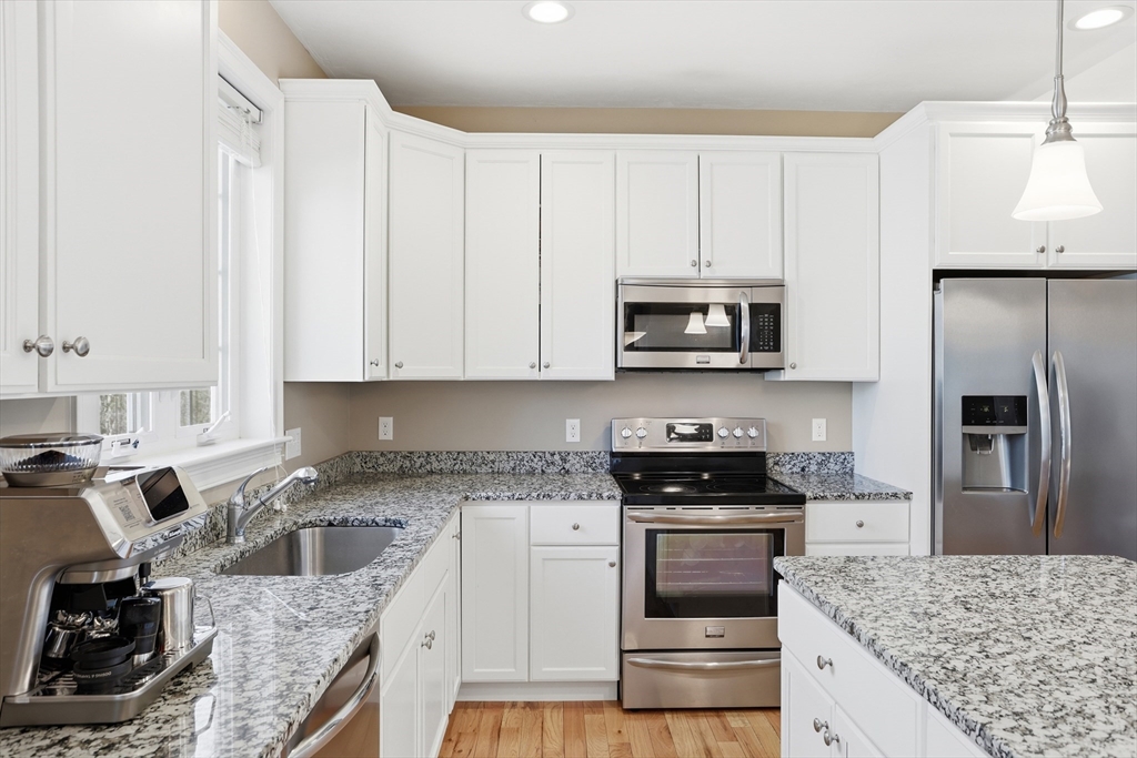 2 Dino Way, Unit 52 Milford, MA 01757 - Photo 13 of 41 a kitchen with granite countertop a stove sink and refrigerator