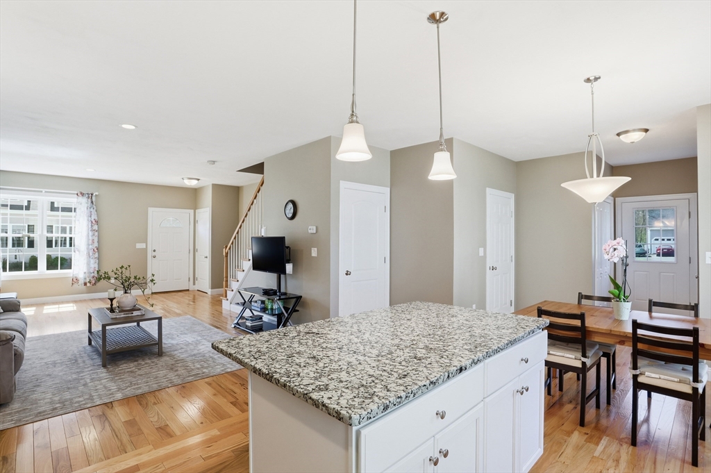 2 Dino Way, Unit 52 Milford, MA 01757 - Photo 17 of 41 a living room with granite countertop kitchen island furniture and a chandelier