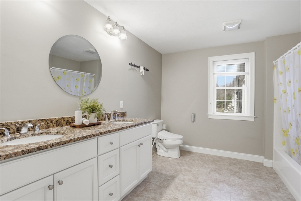 2 Dino Way, Unit 52 Milford, MA 01757 - Photo 26 of 41 a en suite bathroom with a granite countertop sink and a mirror