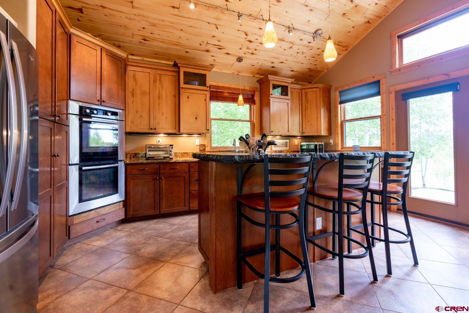 305 Roper Lane Almont, CO 81210 - Photo 18 of 35 a kitchen with stainless steel appliances granite countertop table chairs and a refrigerator