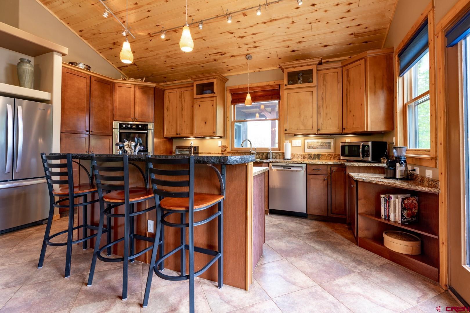 305 Roper Lane Almont, CO 81210 - Photo 19 of 35 a kitchen with a table chairs microwave and cabinets