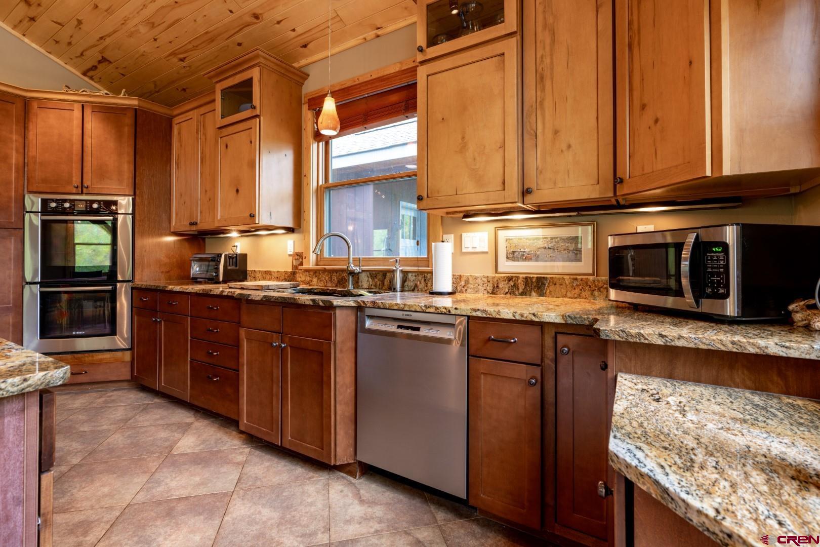 305 Roper Lane Almont, CO 81210 - Photo 20 of 35 a kitchen with stainless steel appliances granite countertop a stove a sink and a microwave