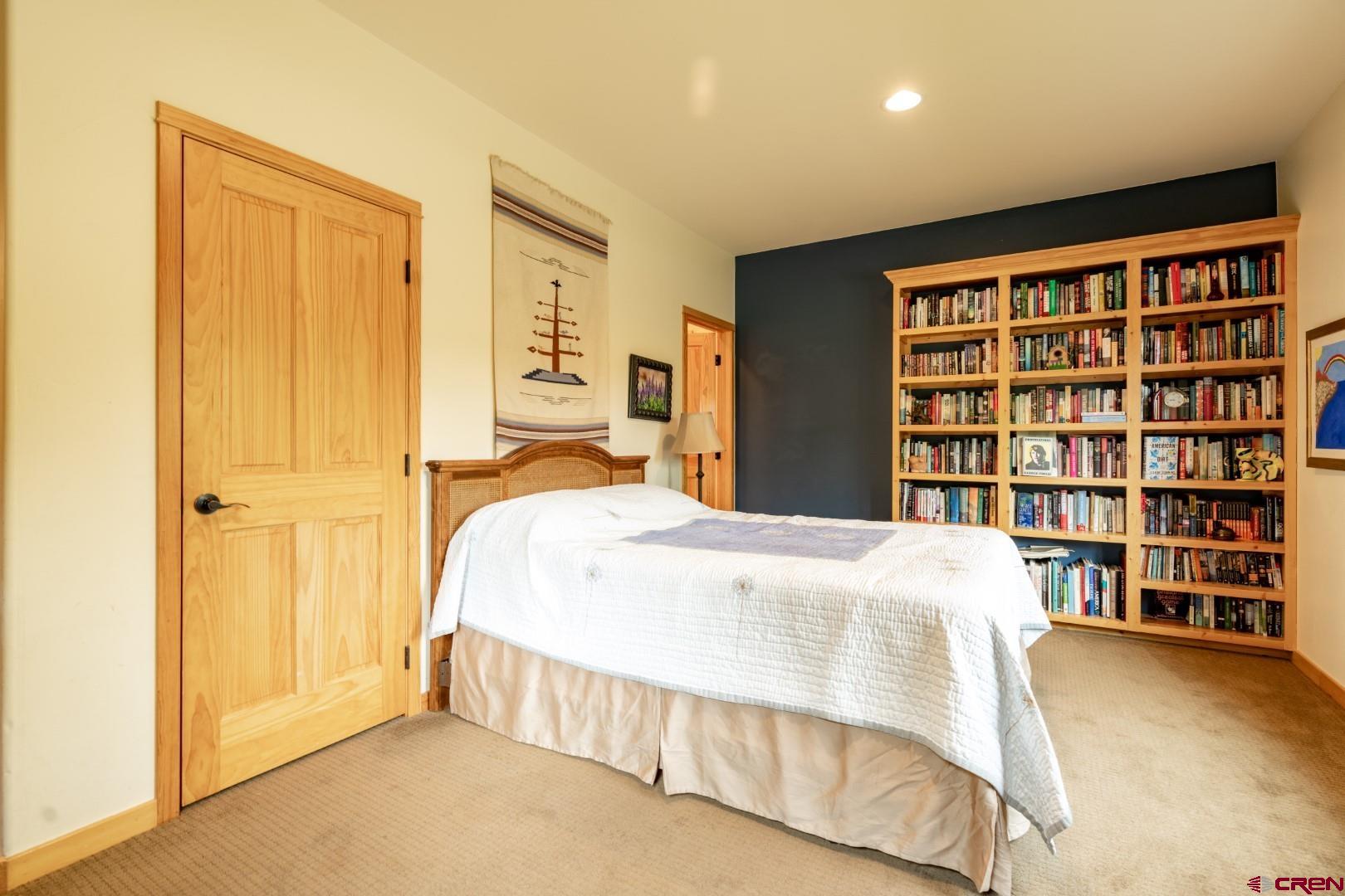 305 Roper Lane Almont, CO 81210 - Photo 26 of 35 a bedroom with a bed and a book shelf