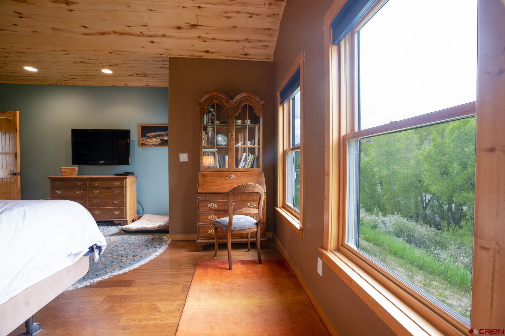 305 Roper Lane Almont, CO 81210 - Photo 31 of 35 a living room with a fireplace furniture a flat screen tv and a floor to ceiling window