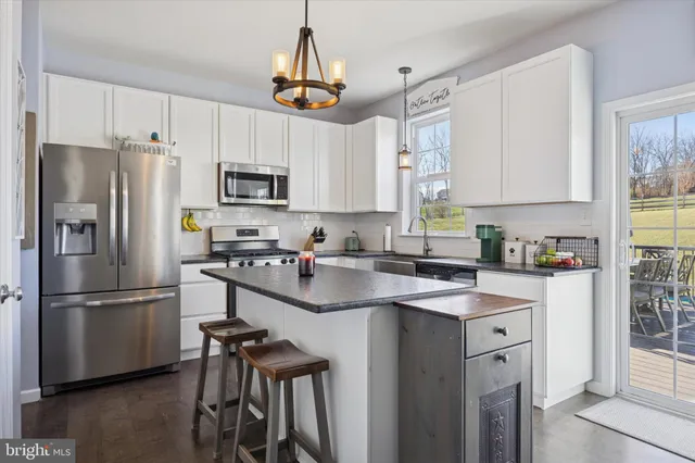 a kitchen with stainless steel appliances a refrigerator a sink a stove a microwave and cabinets