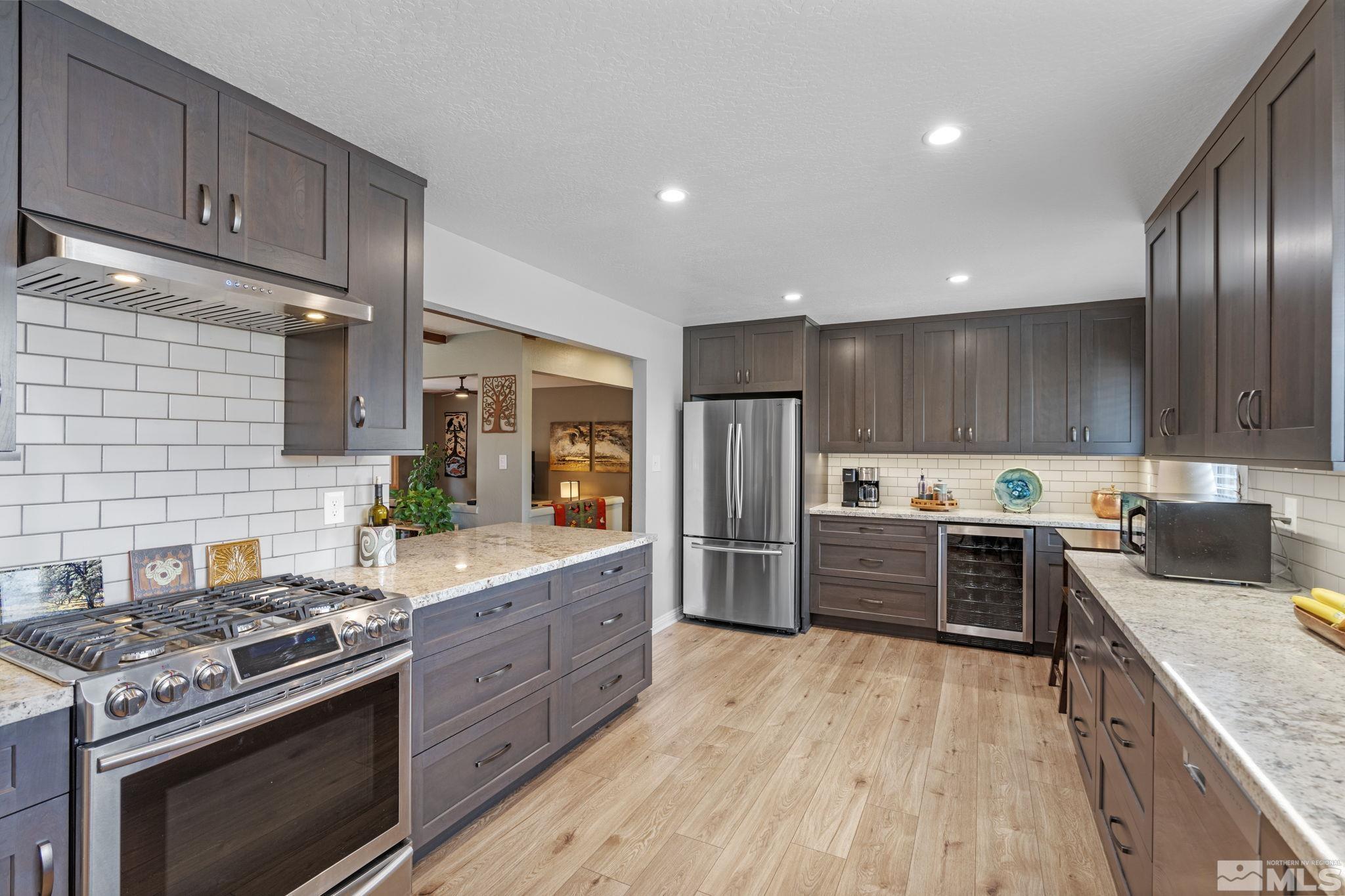 690 Shamrock Lane Reno, NV 89509 - Photo 11 of 30 a kitchen with stainless steel appliances granite countertop wooden cabinets stove top oven and sink