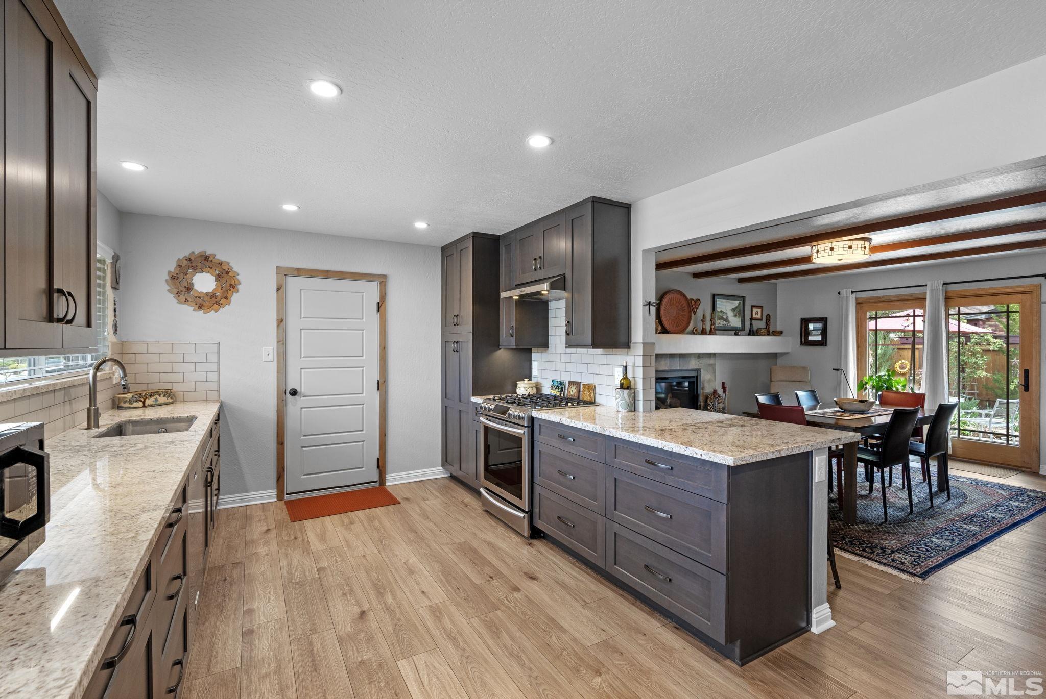 690 Shamrock Lane Reno, NV 89509 - Photo 12 of 30 a kitchen with stainless steel appliances kitchen island granite countertop a stove and a refrigerator