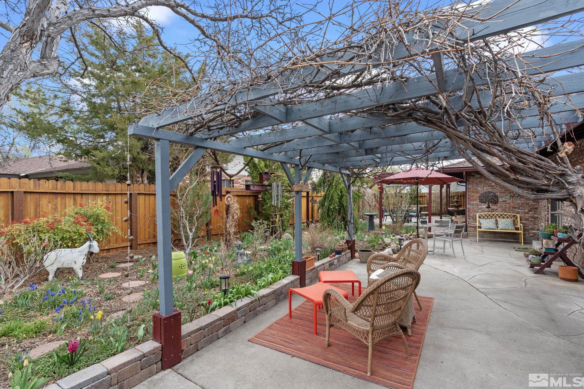 690 Shamrock Lane Reno, NV 89509 - Photo 27 of 30 a view of a patio with a table and chairs under an umbrella with a tree