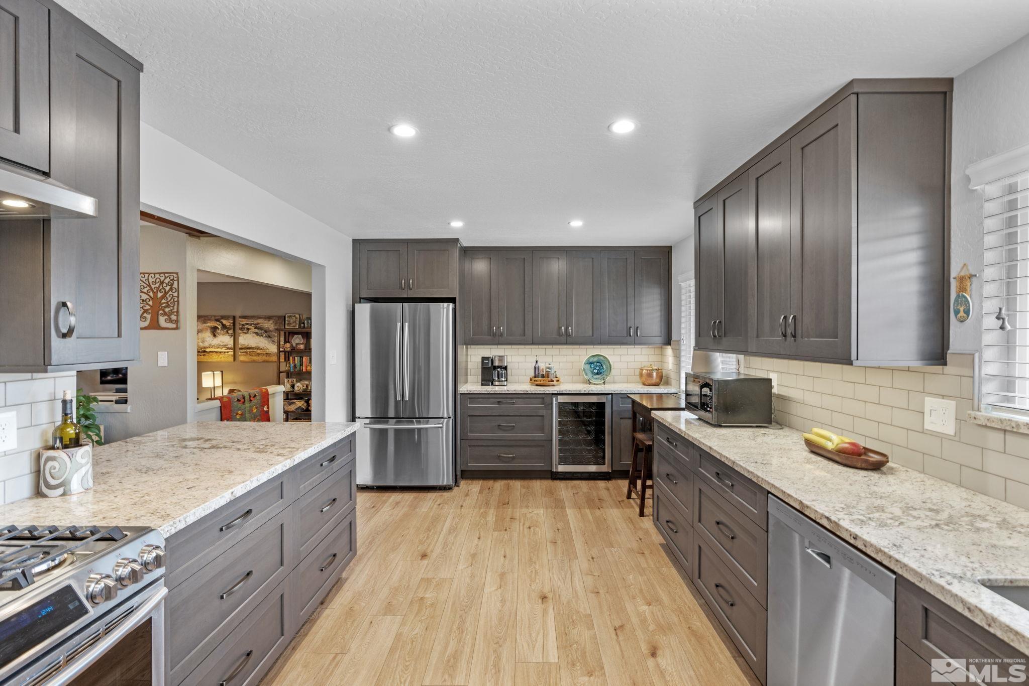 690 Shamrock Lane Reno, NV 89509 - Photo 10 of 30 a large kitchen with stainless steel appliances granite countertop a lot of counter space and wooden floor