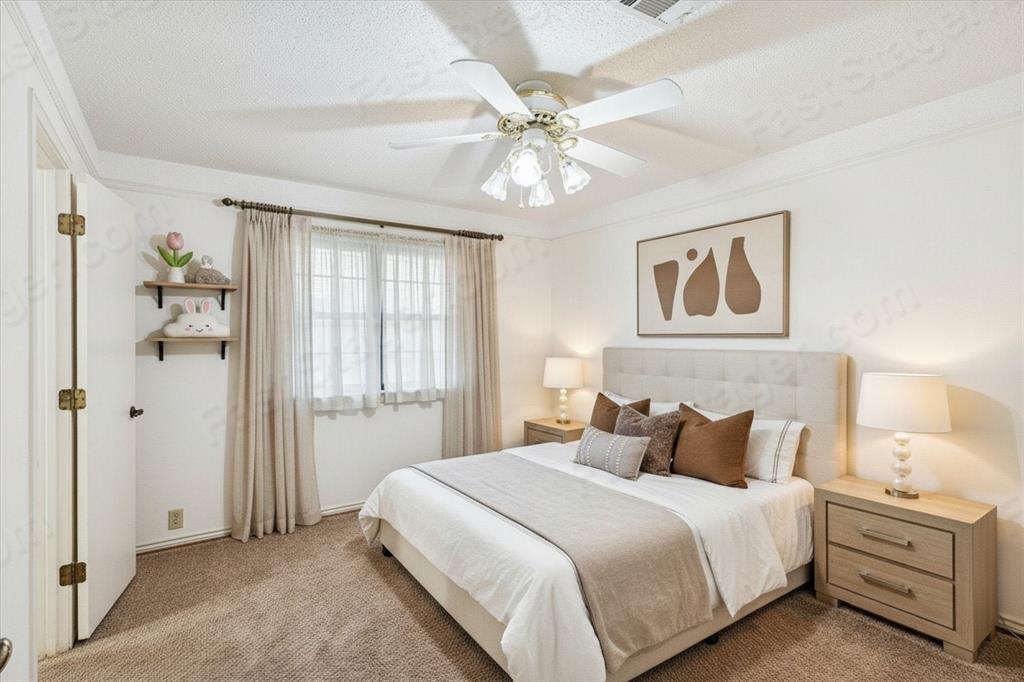 805 Newport Road Fort Worth, TX 76120 - Photo 15 of 27 a bedroom with a bed and a chandelier