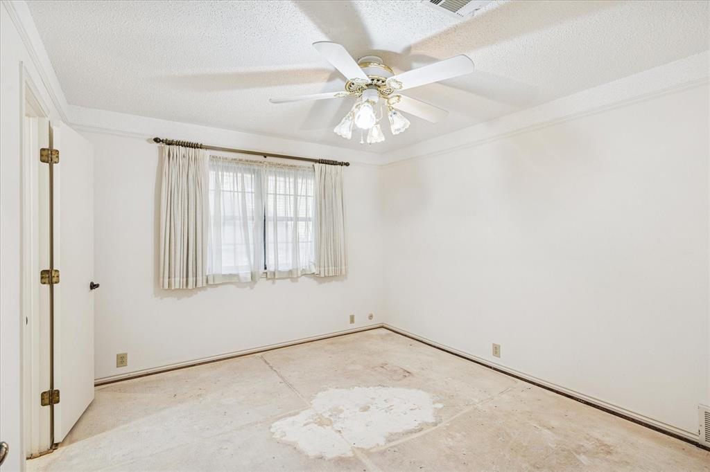 805 Newport Road Fort Worth, TX 76120 - Photo 16 of 27 an empty room with a window and ceiling fan