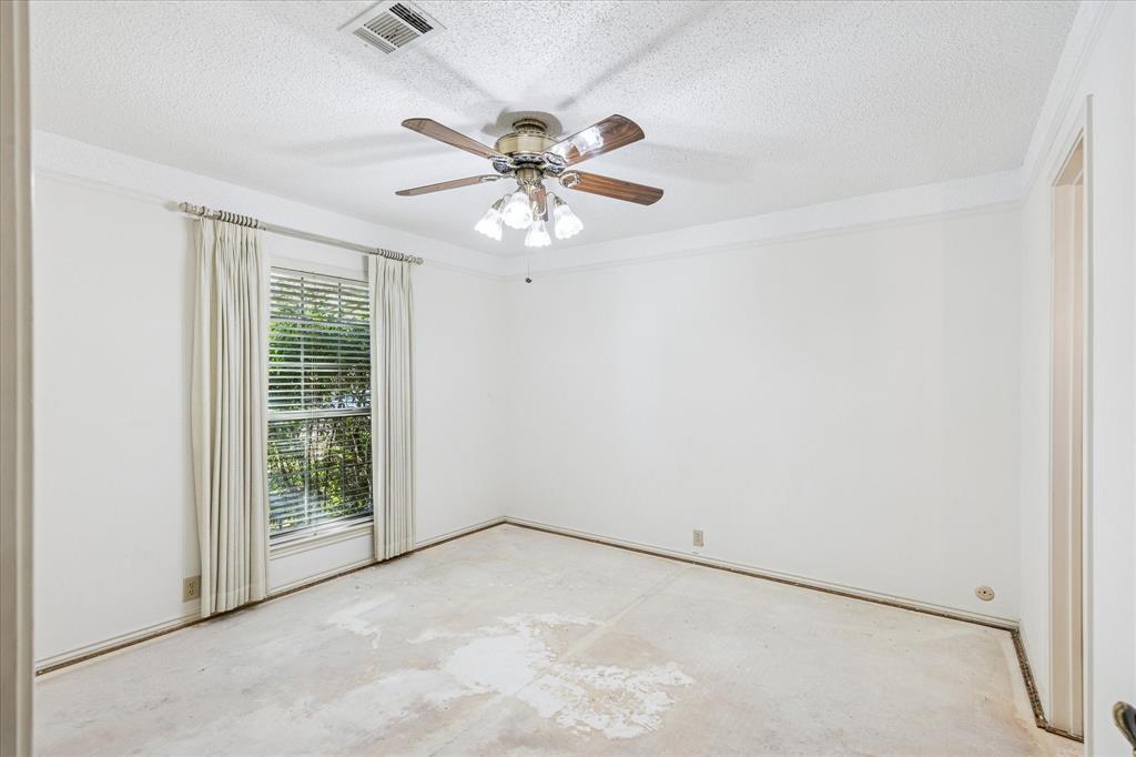 805 Newport Road Fort Worth, TX 76120 - Photo 17 of 27 an empty room with windows and fan