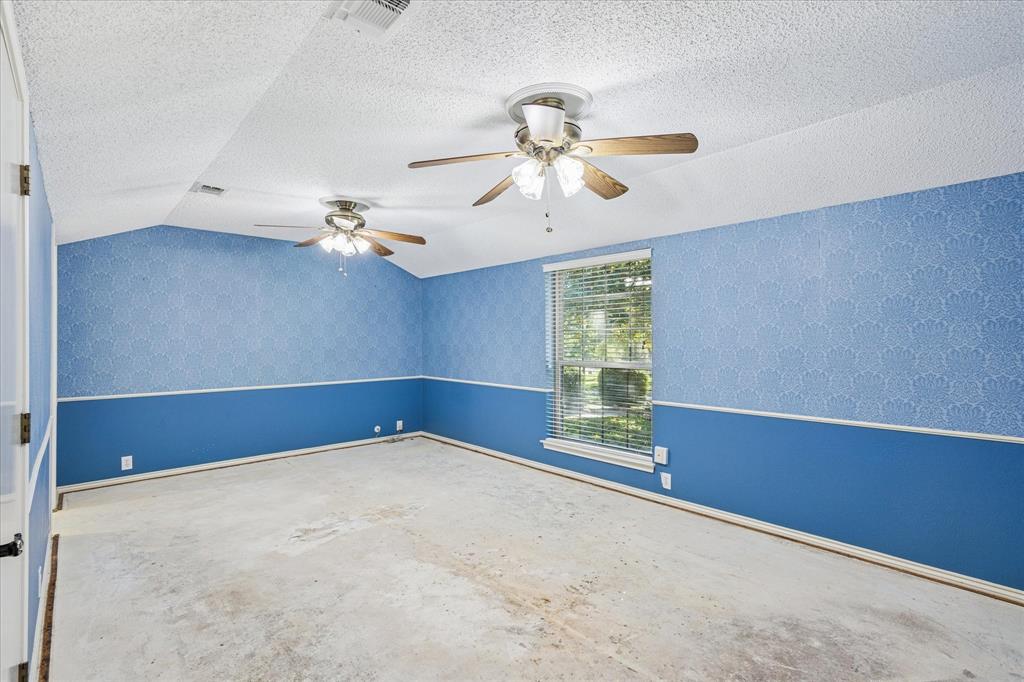 805 Newport Road Fort Worth, TX 76120 - Photo 23 of 27 an empty room with windows and chandelier fan