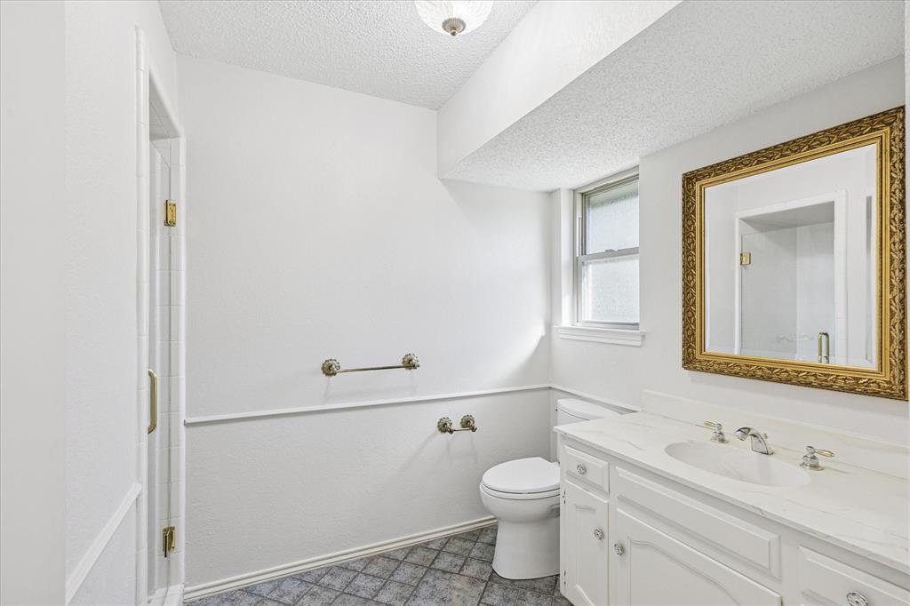805 Newport Road Fort Worth, TX 76120 - Photo 24 of 27 a bathroom with a sink mirror vanity and toilet