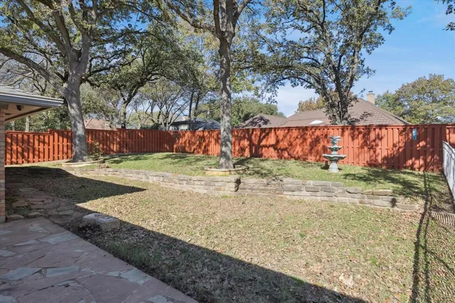 a view of a yard with wooden fence