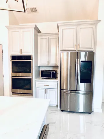 a kitchen with stainless steel appliances a refrigerator and a stove top oven
