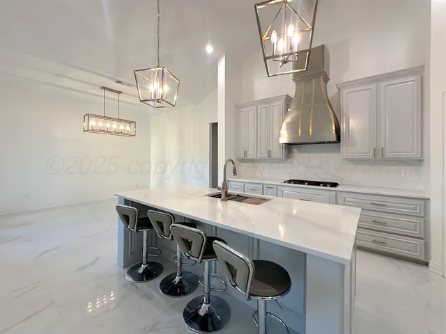 a kitchen with stainless steel appliances granite countertop a sink a stove and a wooden floors