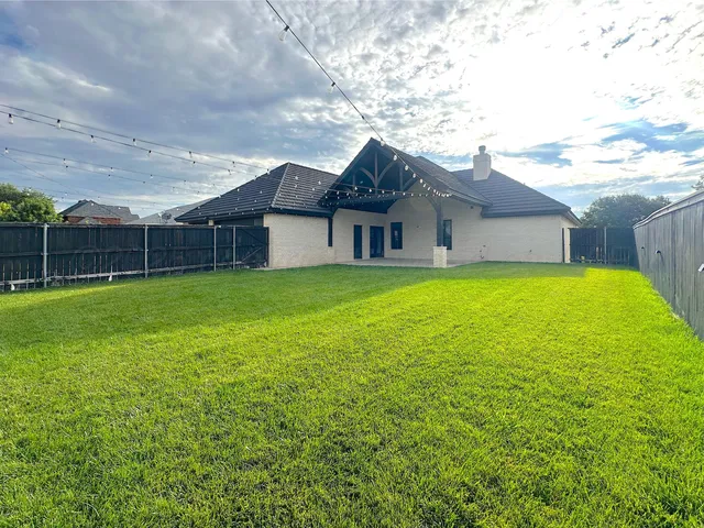 a view of a house with a yard and a fountain
