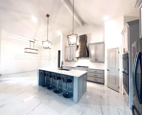 a kitchen with stainless steel appliances granite countertop a sink and a refrigerator